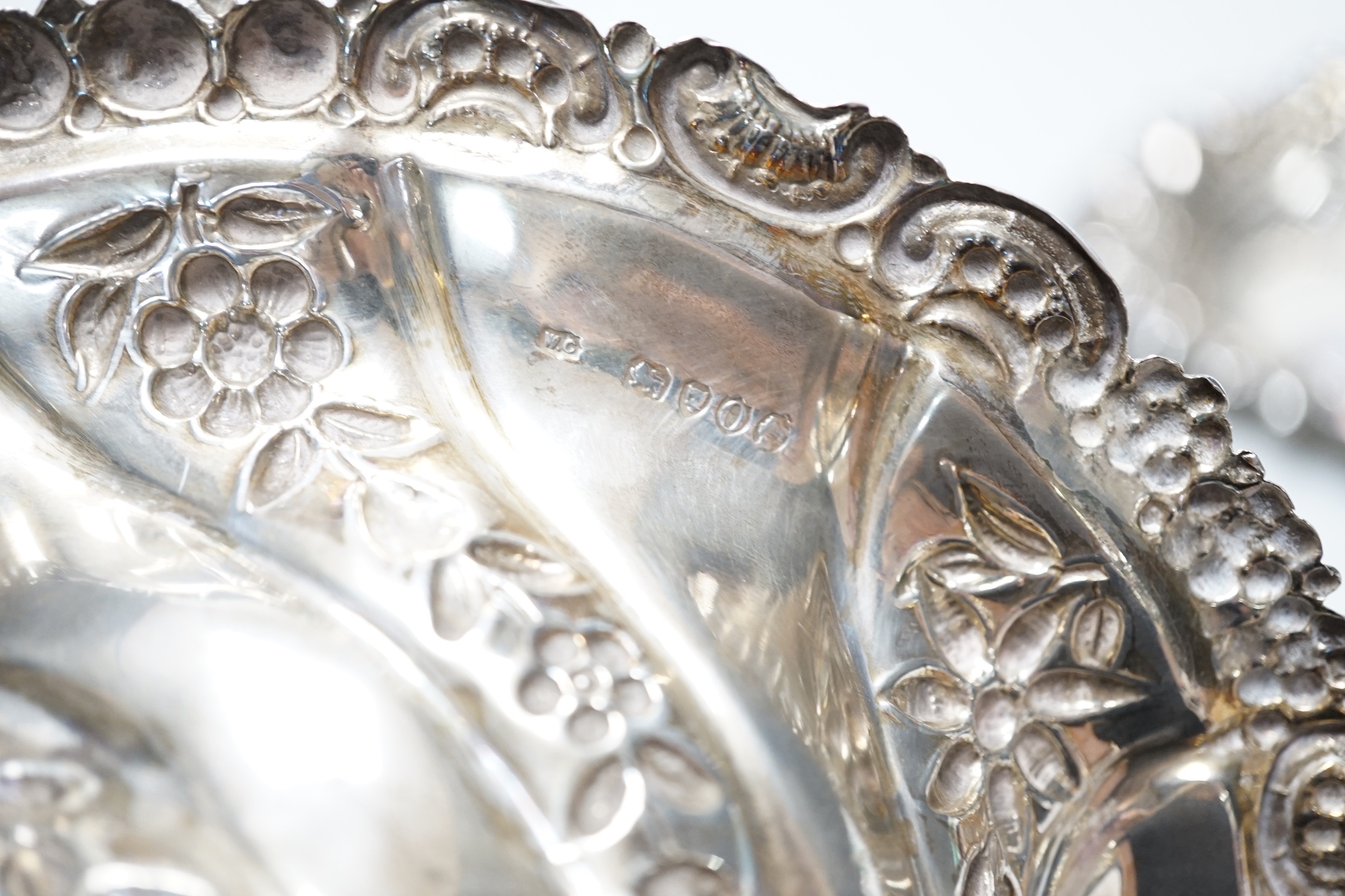 A late Victorian repousse silver oval bowl, William Comyns, London, 1889, 21.1cm and two other smaller silver dishes, 10.8oz.